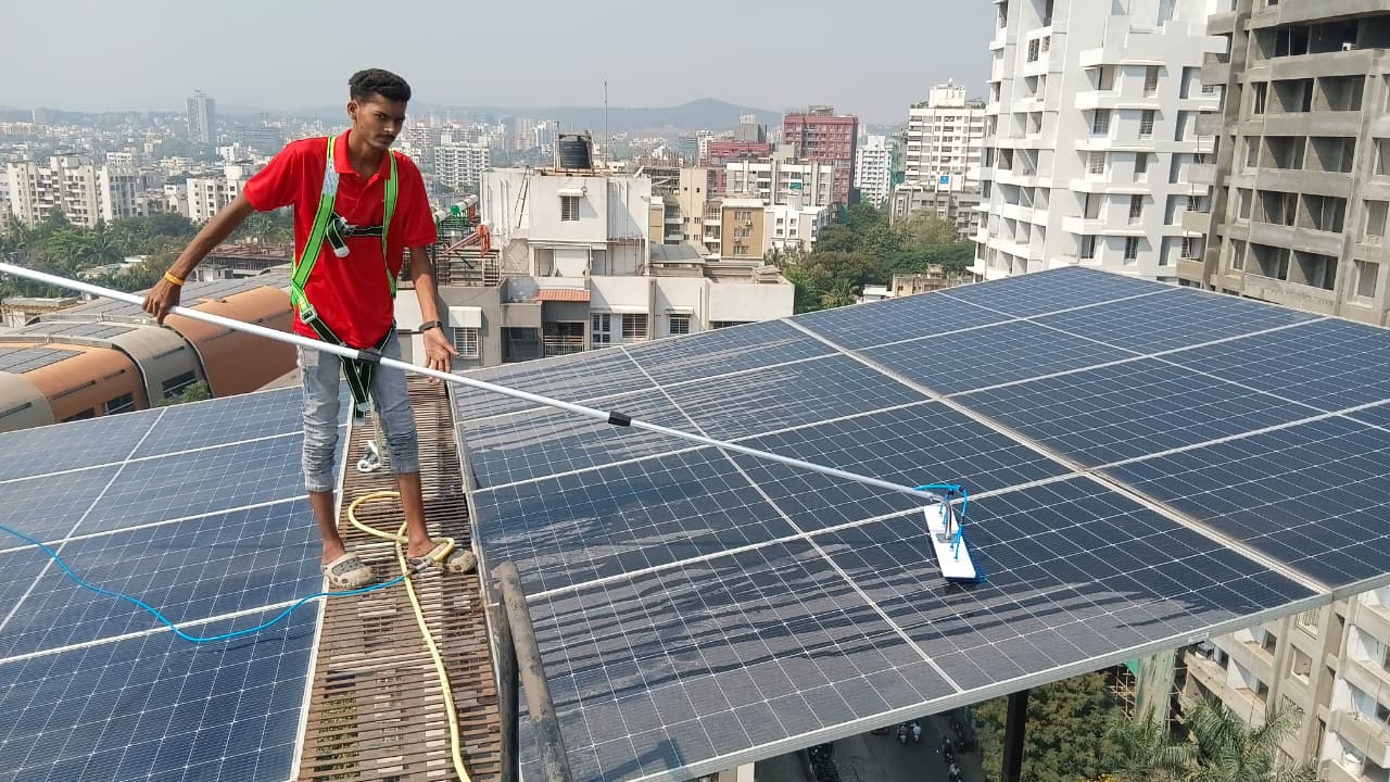 Technician in full safety harness with water-fed telescopic pole